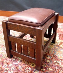 Close-up of footstool in rich reddish-brown color with brown leather.